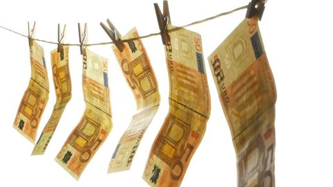 Euro money hangs on a rope attached with clothespins. 