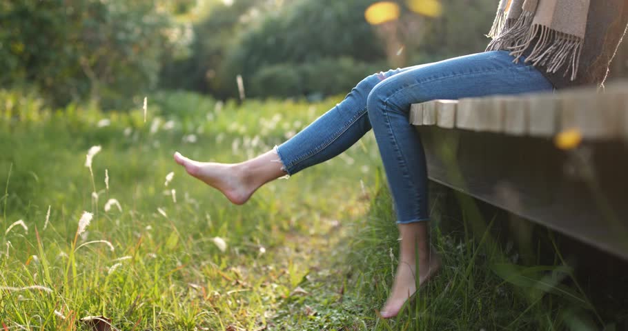 Woman relax by the lake sitting on the edge of a wooden jetty