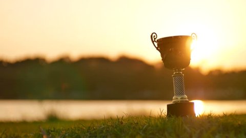 winning trophy slide shot on sunset bakckground
