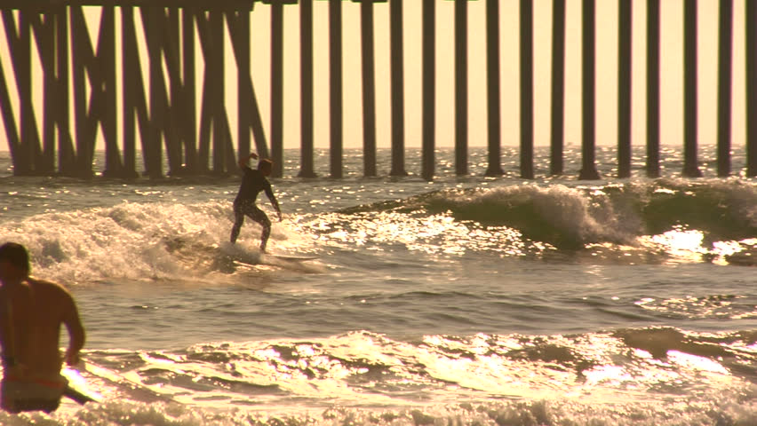 Surfer at Huntington Beach at sunset.