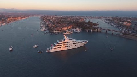 Aerial orbit view of luxury super yacht or mega-yacht docked in harbor