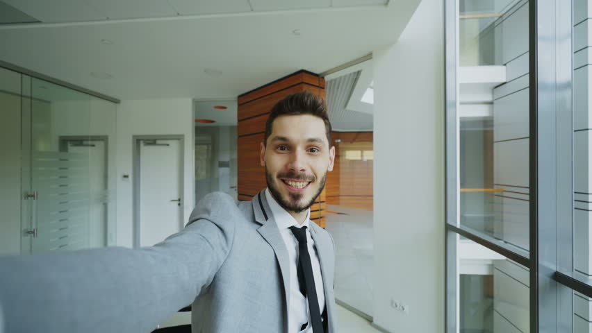 POV of young businessman in suit taking a selfie photo and have fun in modern office