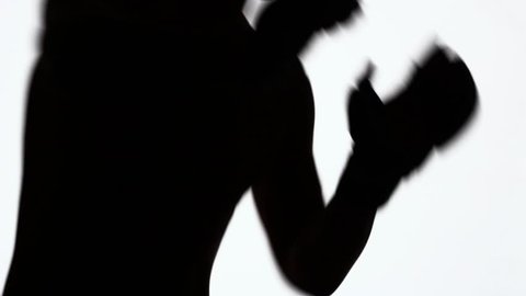 Silhouette of a sporting young man during training on fights without rules. Strikes with fists and elbows. Close-up of a profile of a hand and a torso with muscles. Black object isolated on white.