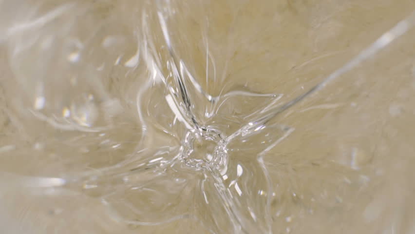Pouring olive oil into a glass in slowmotion