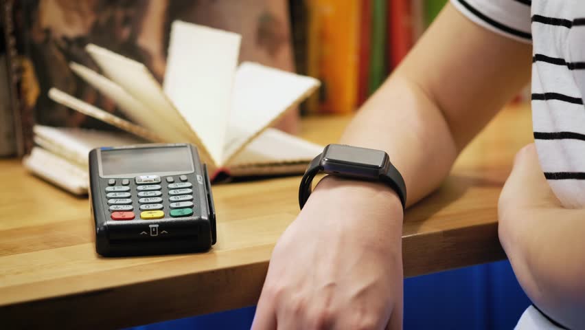 Customer paying with NFC technology by smart watch contactless on terminal in modern cafe. | Shutterstock HD Video #1007172307