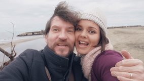 Cute girlfriend and boyfriend taking video with camera in vacation in winter