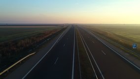 Aerial drone view of sunset over highway and agriculture fields