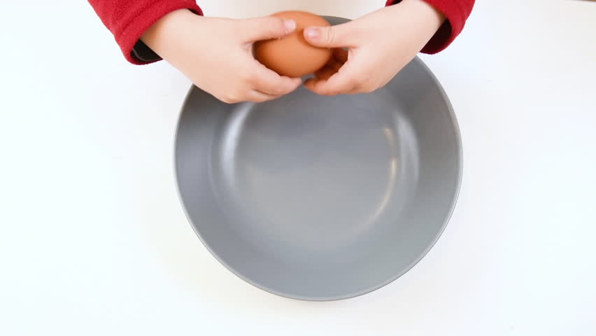 Baby hands fail cracking egg surprise explosion high angle view concept of inexperience exploration and acquiring ability Royalty-Free Stock Footage #1007185336