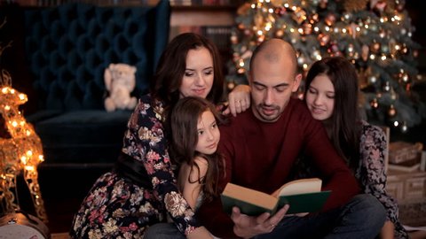 In the New Year's atmosphere, the father reads a book to his family