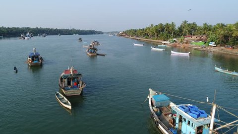 Beautiful tropical river landscape and fishing ships in it. Aerial camera flight over several original indian fishing boats anchored in the river and raised above for  long shot. Aerial view.