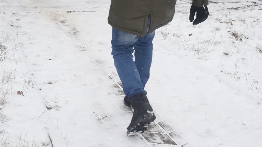 Young stylishly dressed man while walking in the Park in winter slipped and lost his balance Royalty-Free Stock Footage #1007200711