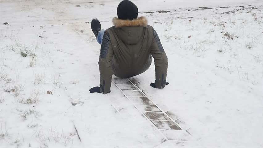 Young stylishly dressed man while walking in the Park in winter slipped and lost his balance Royalty-Free Stock Footage #1007200717