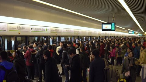 Shanghai, China - January 15, 2018: A large crowd of people enters the train car in the Shanghai Metro