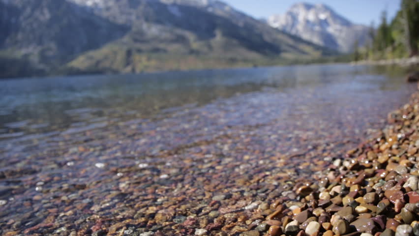 Close Up Waves of Water Crashing onto Rocks and Shore of Mountain Lake Jenny