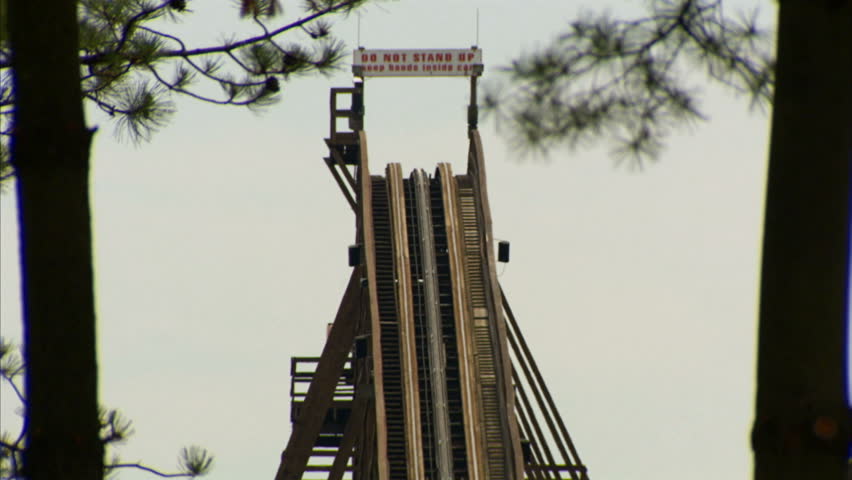 A roller coaster ascending for the first big drop at a theme park 