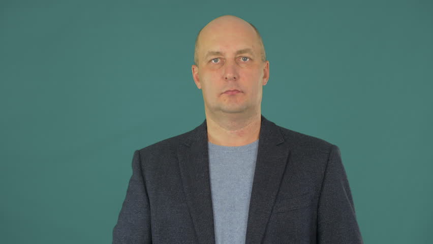 A man in a suit puts on headphones. Handsome adult man putting on headphones