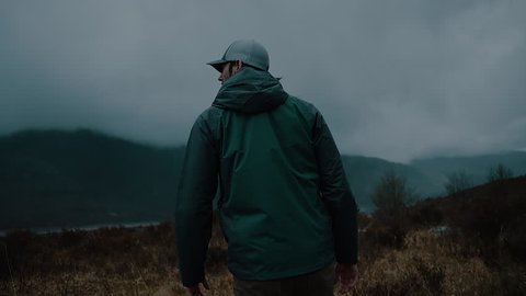 Man Walking in a Dark Misty Mountain Field