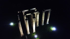 Aerial drone night video of iconic pillars of Temple of Olympian Zeus, Athens historic center, Attica, Greece