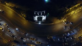 Aerial drone bird's eye view night video of iconic Gate and Arch of Hadrian in Amalias Avenue, Athens historic center, Attica, Greece