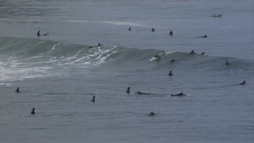 Popular surf spot yields a decent long-board wave two different surfers ride.
