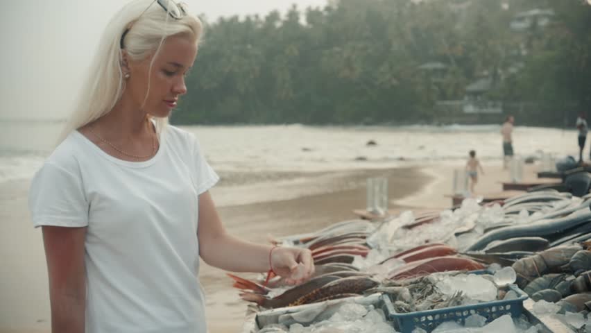 Woman hold a sea bass fresh fish in fish market near beach tourist asia ocean vacation restaurant cafe