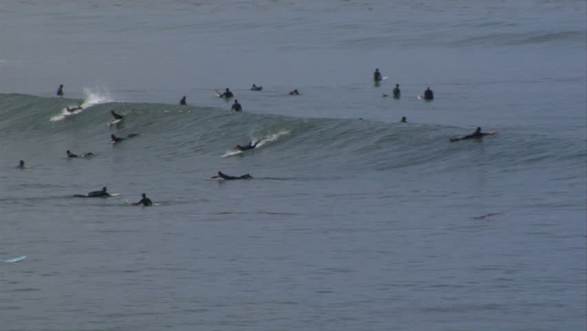 Popular surf spot yields a decent long-board wave two different surfers ride.