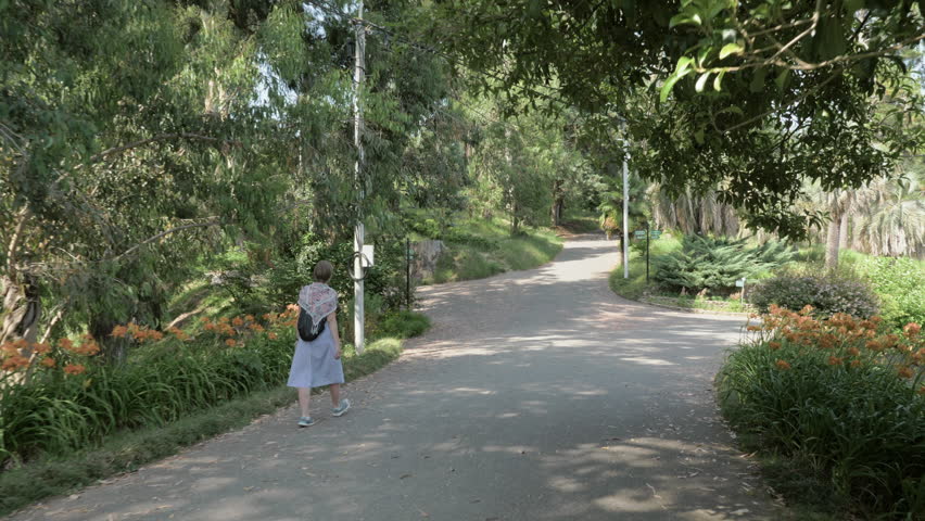 Young girl walking in tropical botanical garden. Batumi, Georgia
