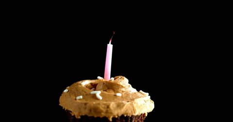 Blowing candle out on chocolate cupcake 4K slow motion