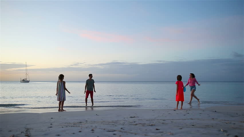Happy family playing with flying disk at beach