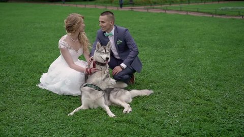 Bride and groom with husky dogs in park