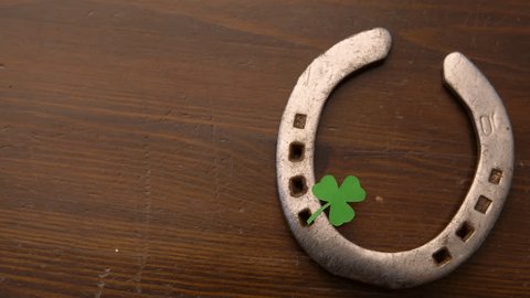 holidays and st patrick's day concept - horseshoe with shamrock on wooden background