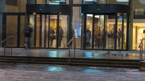  the flow of people passing through the revolving door of the office building at the end of the working day,time lapse