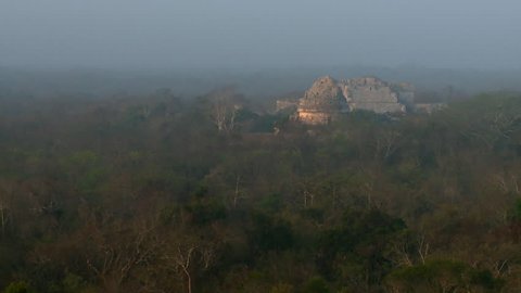 View of forest and ruined Mayan temple at dawn in Chichen Itza, Mexico circa September 2010