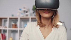 Pretty woman wearing virtual reality glasses waving his hands sit on the sofa at home feel happy smiling innovation looking entertainment gadget new tech visual game portrait close up slow motion