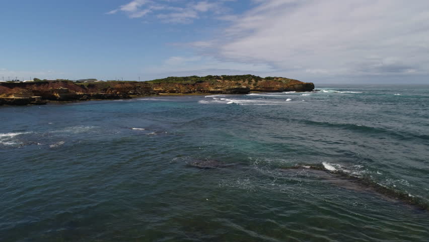 Drone soaring up over the rocky coastline to reveal Peterborough, Victoria, Australia.
