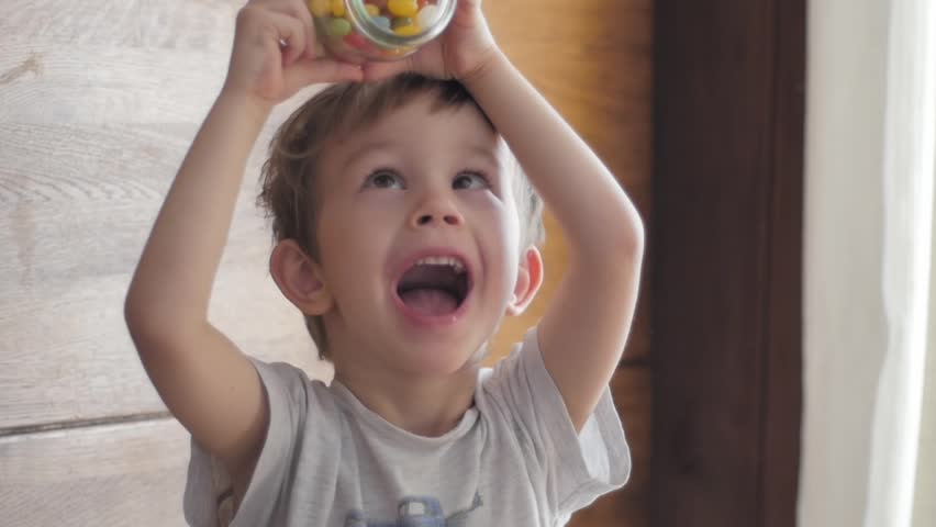 boy eating candies falling from jar Royalty-Free Stock Footage #1007258500