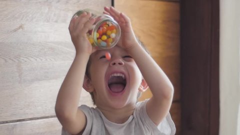 boy eating candies falling from jar