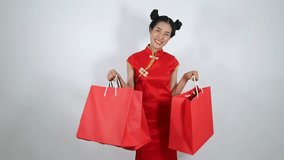 4k video of happy woman holding shopping bag on chinese new year celebration on white background