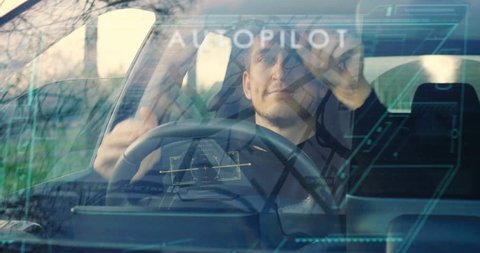 A man drives his futuristic car and when he activates the autopilot the car drives itself and can relax. Concept of: Technology, holography, future, transport and cars.