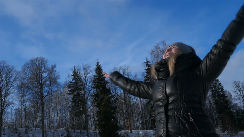 Beautiful girl feels free, on a sunny day, in winter, all in the snow.