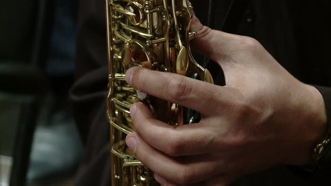 Close-up part of instrument soprano saxophone while playing music.