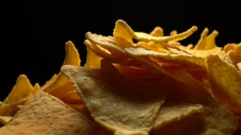 Spicy nachos chips in rotation on black background. Studio shot. Close Up.