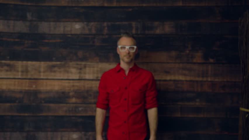 Stylish professional small business man walks up to the camera and crosses his arms