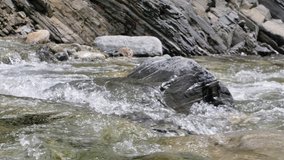 Beautiful water in a mountain river in slow motion video. Shooting speed 60fps, slow motion. Live shooting of the most beautiful nature river mountain water. The camera is not static. River part 3.
