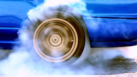 Acceleration detail car spinning wheel and creating white smoke on asphalt street road, Automobile and automotive drag car burnout tire rubber prepare for race or drift, Close up.