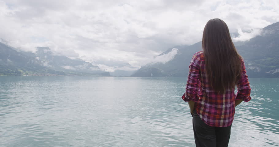 Switzerland - Woman at idyllic Lake Brienz in enjoying view on travel vacation in Swiss Alps looking at view of lake and mountains. RED EPIC SLOW MOTION.