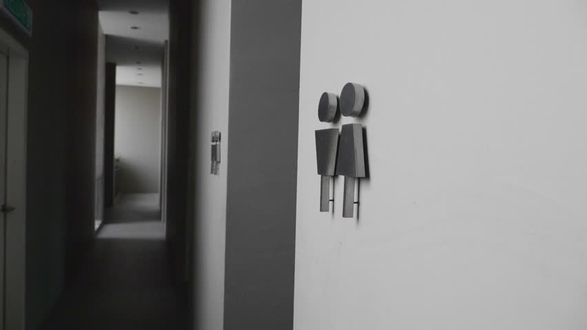 Bathroom restroom silver modern sign on white wall showing male and female symbols. Slow motion shot. Royalty-Free Stock Footage #1007291530