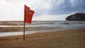 Red warning flag cautions tourists against swimming at this exotic. tropical beach during the rainy season in Phuket. Thailand. 4k video