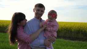 Motion video happy family: father, mother and daughter having fun outdoors in field in summer