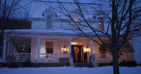 A nighttime low angle stationary winter establishing shot of an upscale Pennsylvania farmhouse decorated for Christmas. Bare trees. Snowing and clean versions.	 	